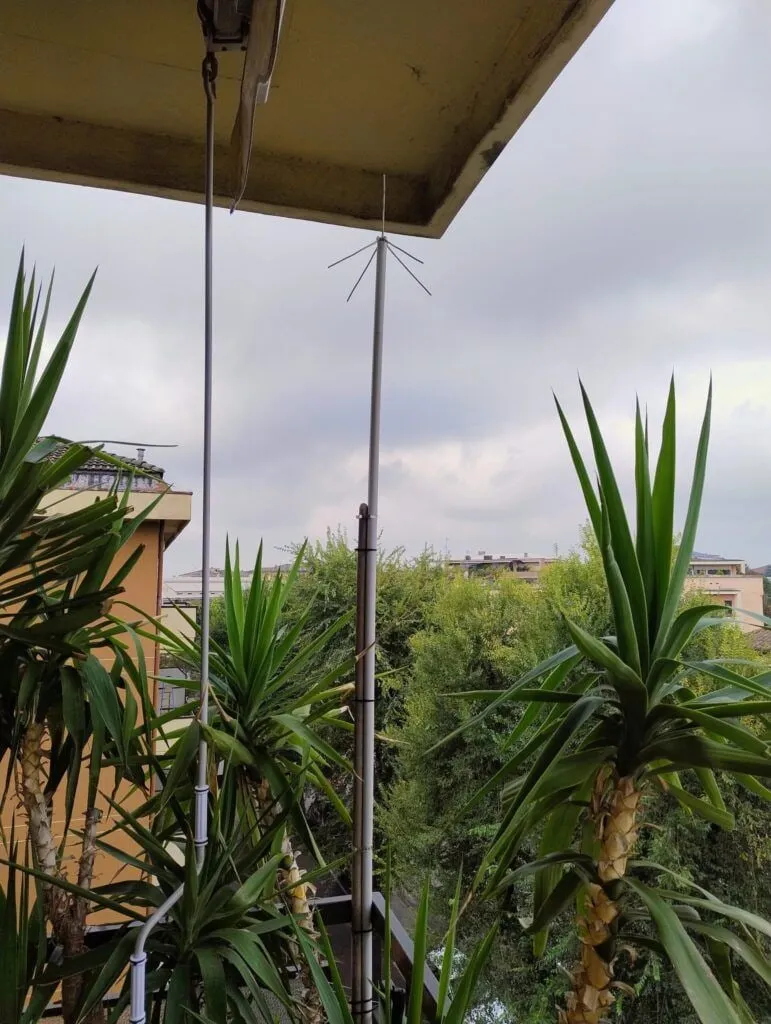 The home-made ground plane antenna on the balcony, among the plants