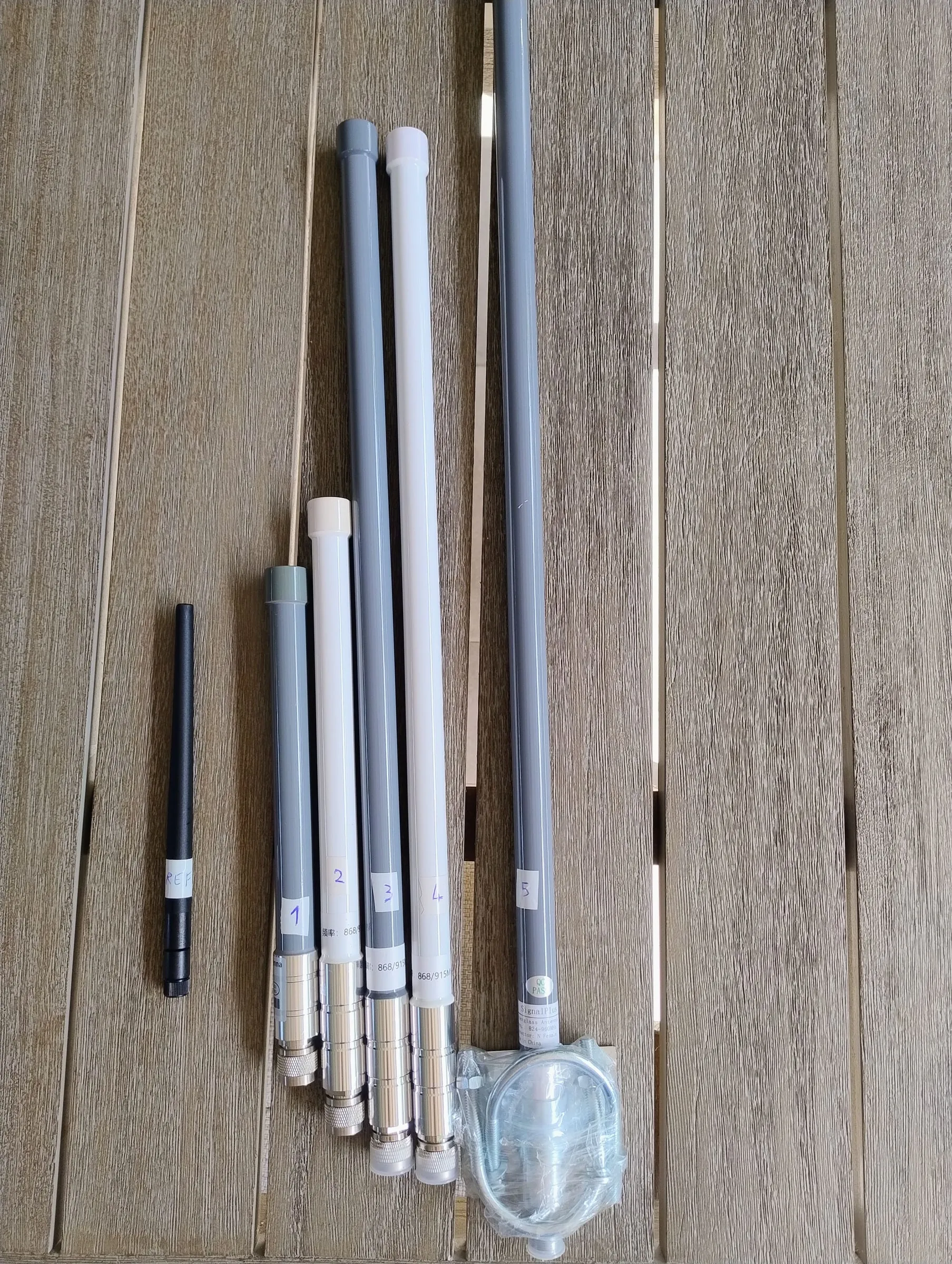 Five antennas of different lengths lying on a wooden table