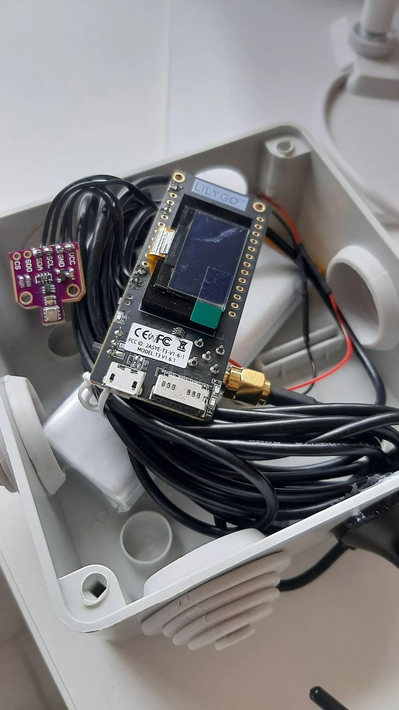 An open station: the TTGO board with its screen, the purple sensor and the coiled antenna cable