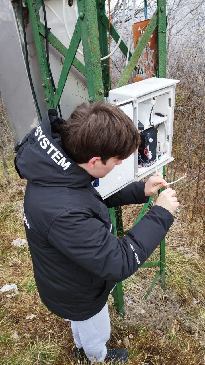 Stefano in front of the LoRa node box fixed to the mast