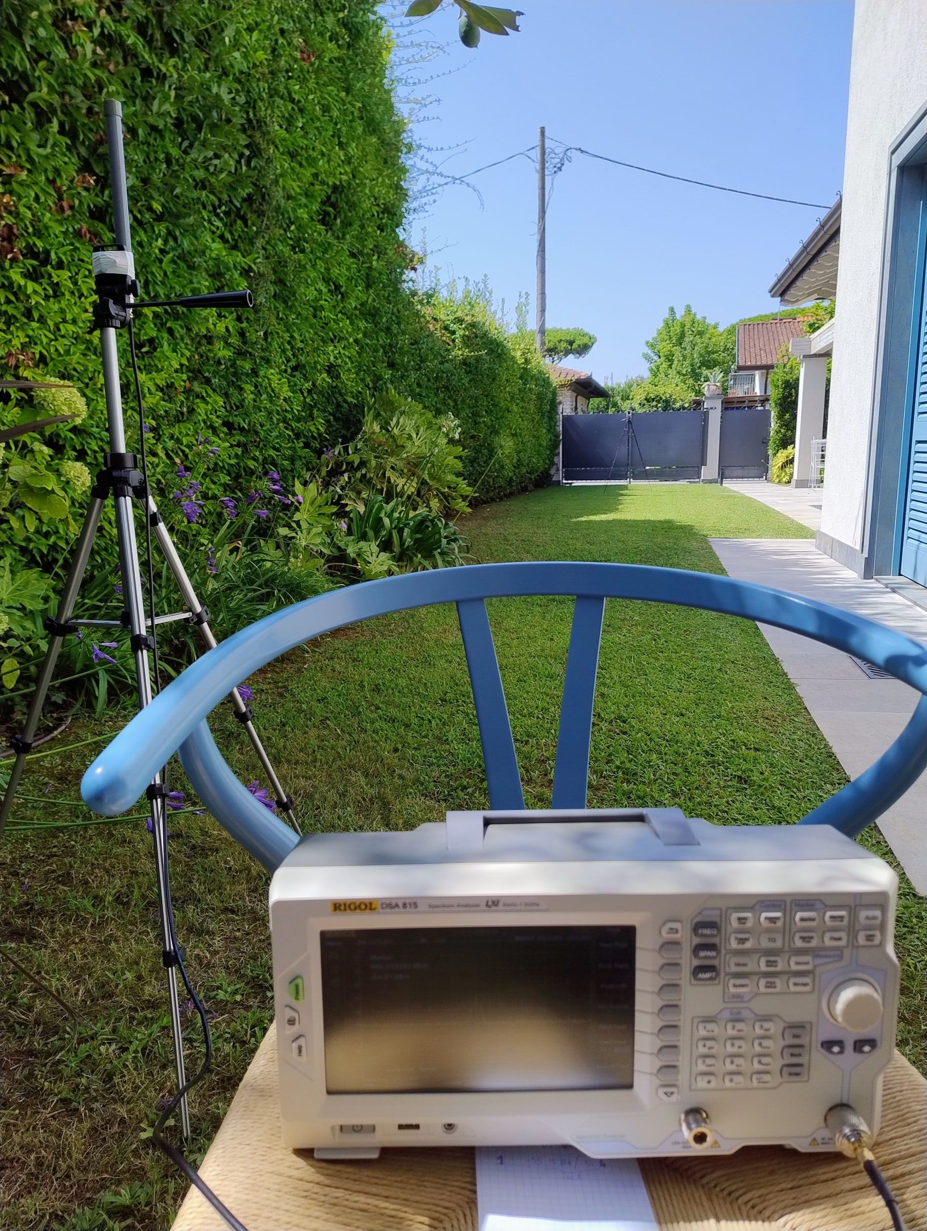 The spectrum analyser on a chair in the garden, with the tripod and antenna in the background