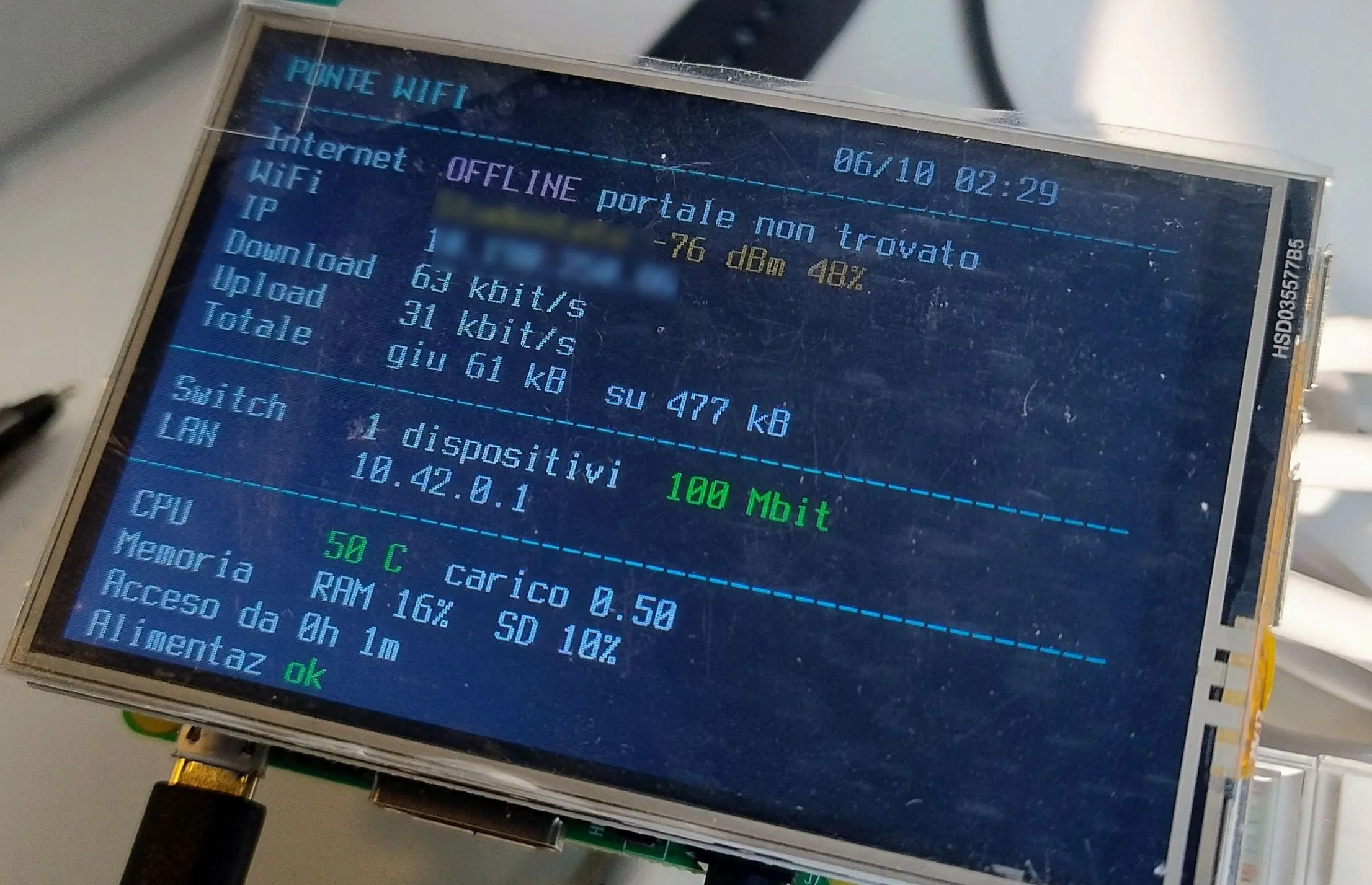 A close-up of the small screen’s lines: internet offline, the WiFi network and signal, download and upload, one device on the switch, temperature, memory and uptime
